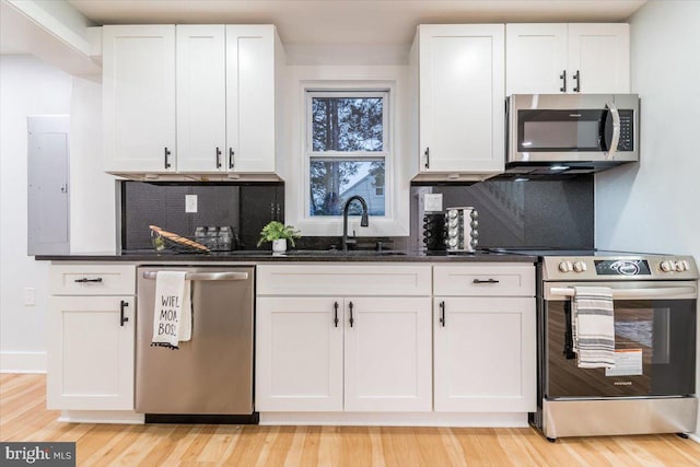 kitchen featuring decorative backsplash, stainless steel appliances, white cabinets, and sink