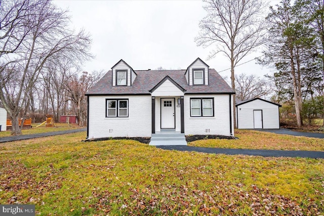 view of front of property featuring a front yard and an outbuilding