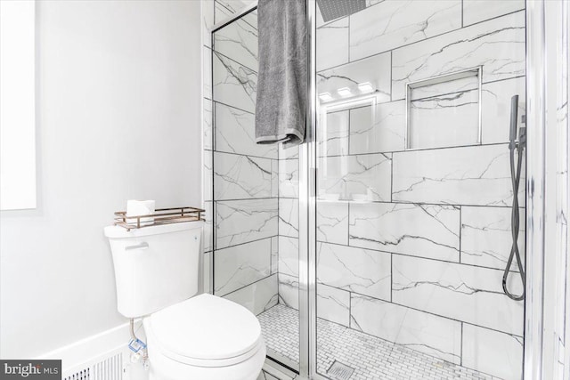 bathroom featuring toilet and an enclosed shower