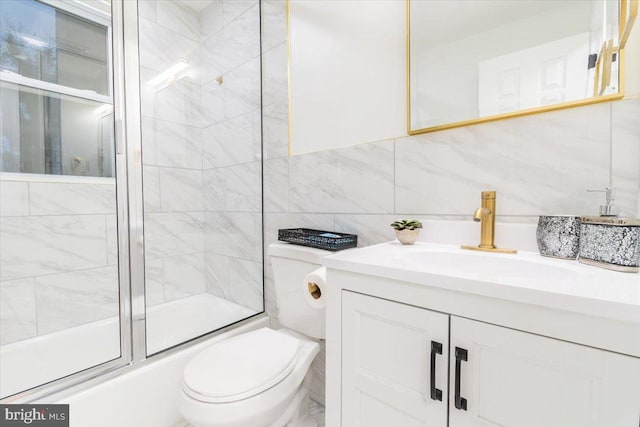 full bathroom featuring vanity, toilet, enclosed tub / shower combo, tile walls, and tasteful backsplash