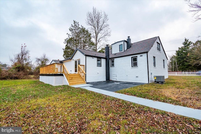 view of front of home featuring a front yard, central AC, and a deck