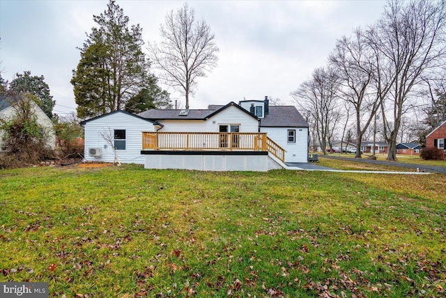 back of property with a yard and a wooden deck