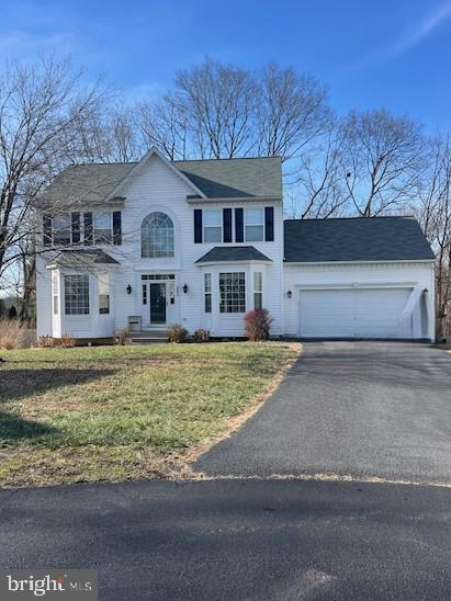 view of front of house with a garage and a front lawn