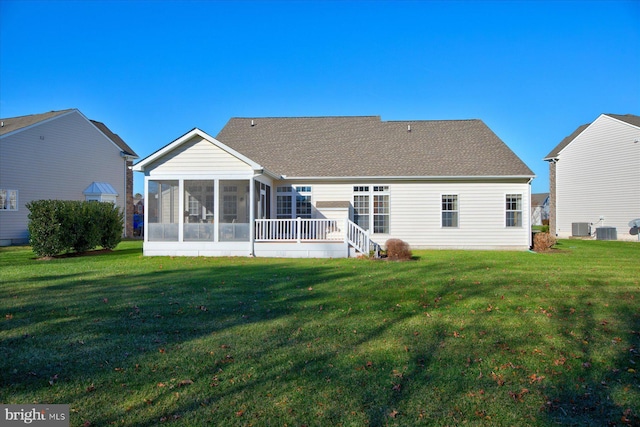 back of house featuring a lawn, a sunroom, and central AC unit