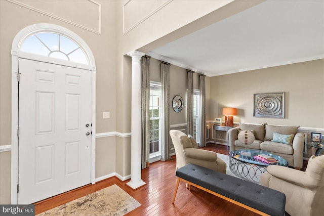 foyer entrance with hardwood / wood-style flooring, ornamental molding, and decorative columns