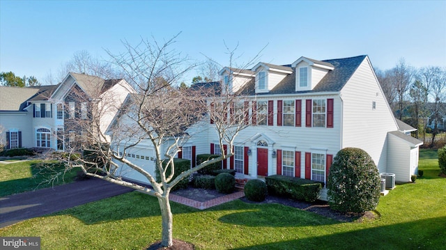 view of front of home featuring central AC and a front lawn