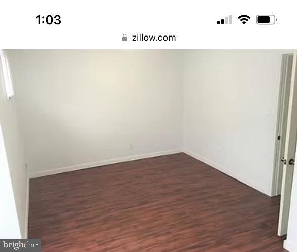 spare room with dark hardwood / wood-style floors