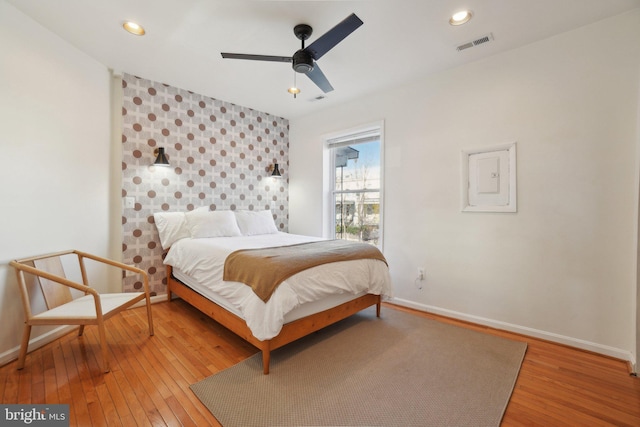 bedroom featuring baseboards, visible vents, wood finished floors, and recessed lighting