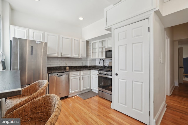 kitchen with dark countertops, stainless steel appliances, and white cabinets