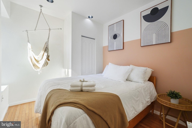 bedroom with baseboards and wood finished floors
