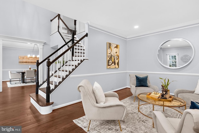 living room featuring an inviting chandelier, dark hardwood / wood-style floors, and crown molding