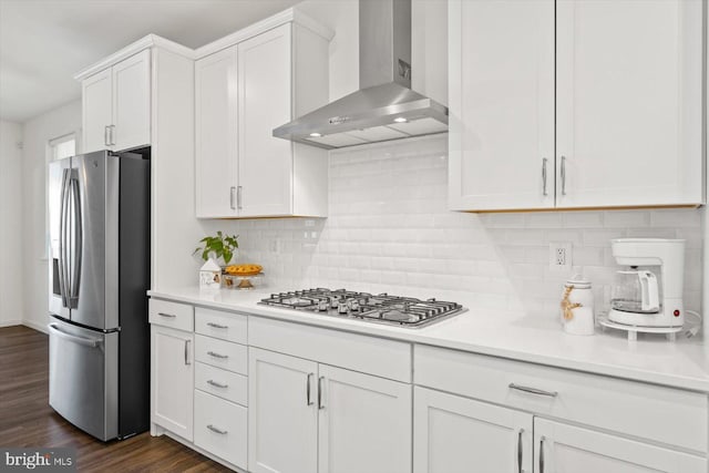 kitchen with wall chimney exhaust hood, tasteful backsplash, dark hardwood / wood-style flooring, white cabinets, and appliances with stainless steel finishes