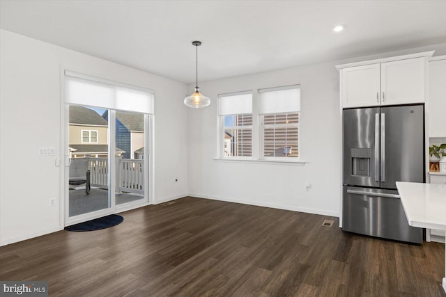 unfurnished dining area with plenty of natural light and dark hardwood / wood-style floors