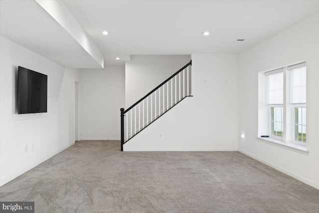 unfurnished living room featuring light colored carpet