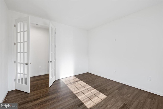 spare room featuring french doors and dark hardwood / wood-style floors