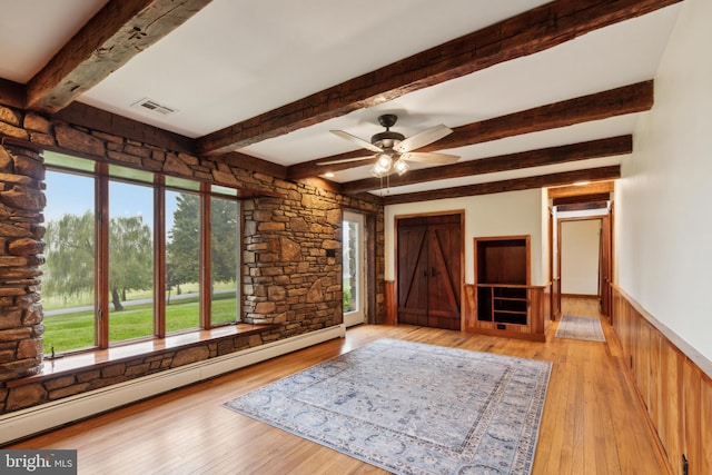 interior space with ceiling fan, beamed ceiling, a baseboard radiator, and light wood-type flooring