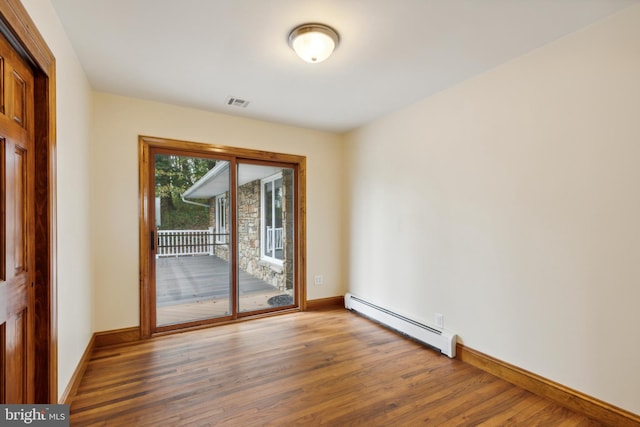 spare room featuring a baseboard radiator and wood-type flooring