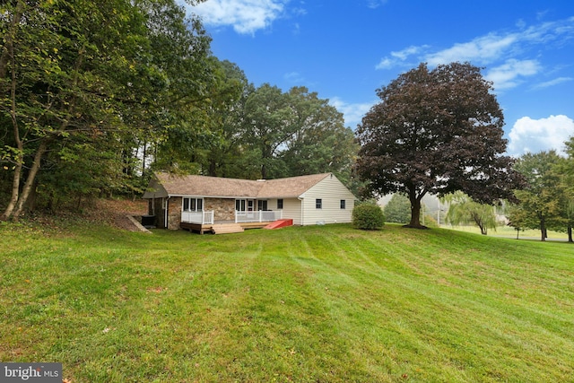 view of front of home with a wooden deck and a front yard