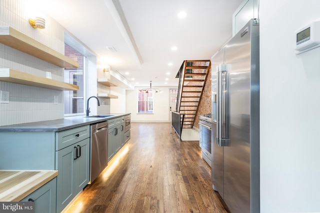 kitchen with decorative backsplash, dark hardwood / wood-style floors, high end appliances, and sink