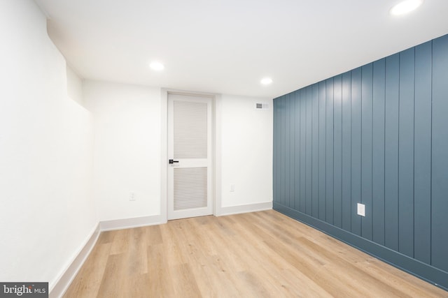 spare room with wooden walls and light hardwood / wood-style floors