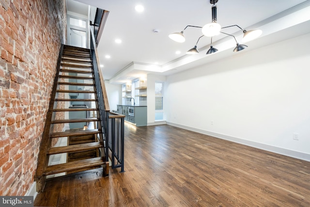 staircase with hardwood / wood-style floors and sink