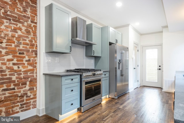 kitchen with decorative backsplash, wall chimney exhaust hood, brick wall, high end appliances, and dark wood-type flooring