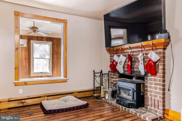 interior space featuring hardwood / wood-style floors, a baseboard radiator, a wood stove, and an AC wall unit