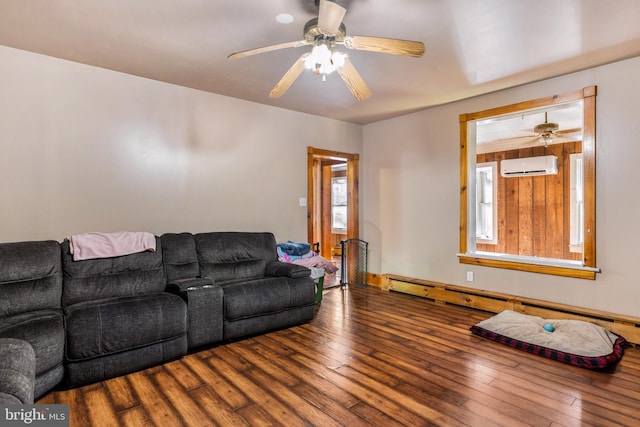 living room with a wall mounted air conditioner, hardwood / wood-style floors, baseboard heating, and ceiling fan