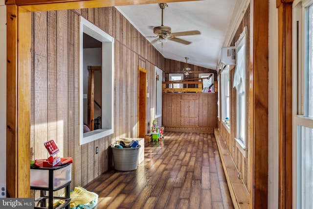 unfurnished sunroom featuring a wall mounted AC, ceiling fan, and vaulted ceiling