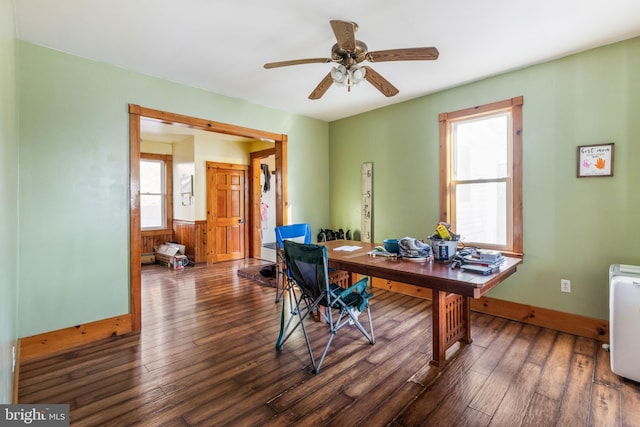 office area featuring dark hardwood / wood-style flooring, ceiling fan, and wood walls