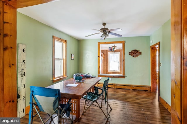 dining area featuring dark hardwood / wood-style flooring, a baseboard radiator, ceiling fan, and a healthy amount of sunlight