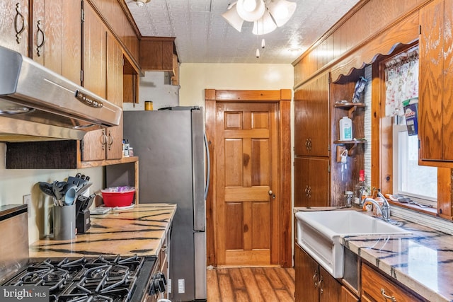 kitchen featuring ceiling fan, sink, range with gas cooktop, ventilation hood, and a textured ceiling