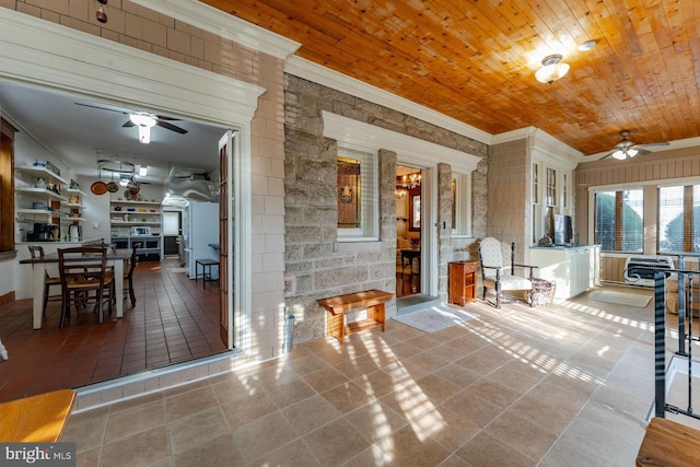 interior space with ceiling fan, wooden ceiling, and crown molding