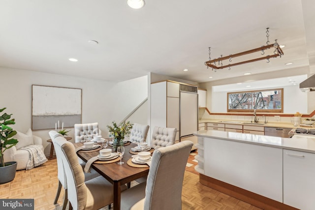 dining space featuring sink and light parquet floors