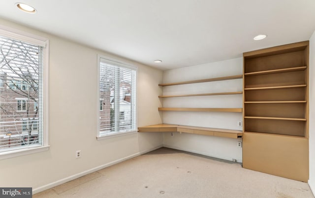 unfurnished office with light colored carpet and built in desk