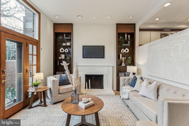 living room featuring a healthy amount of sunlight and a brick fireplace