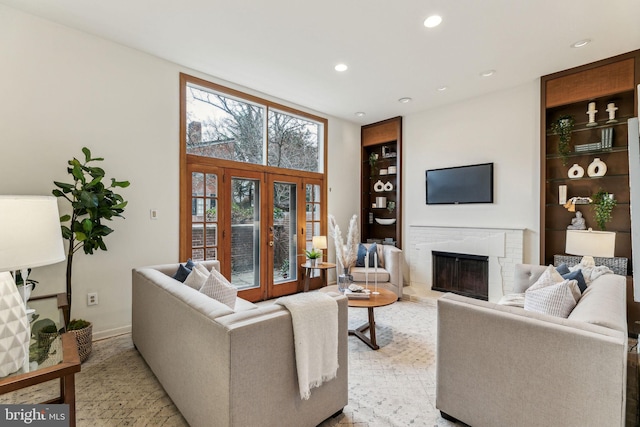 living room with a fireplace, french doors, and built in features