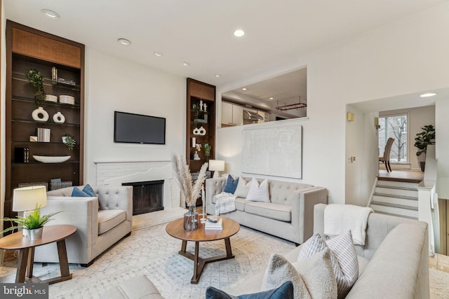 living room with built in features and a brick fireplace