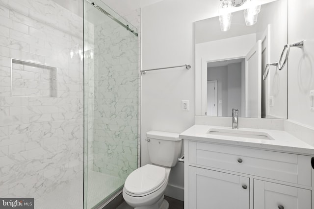 bathroom featuring toilet, walk in shower, and vanity