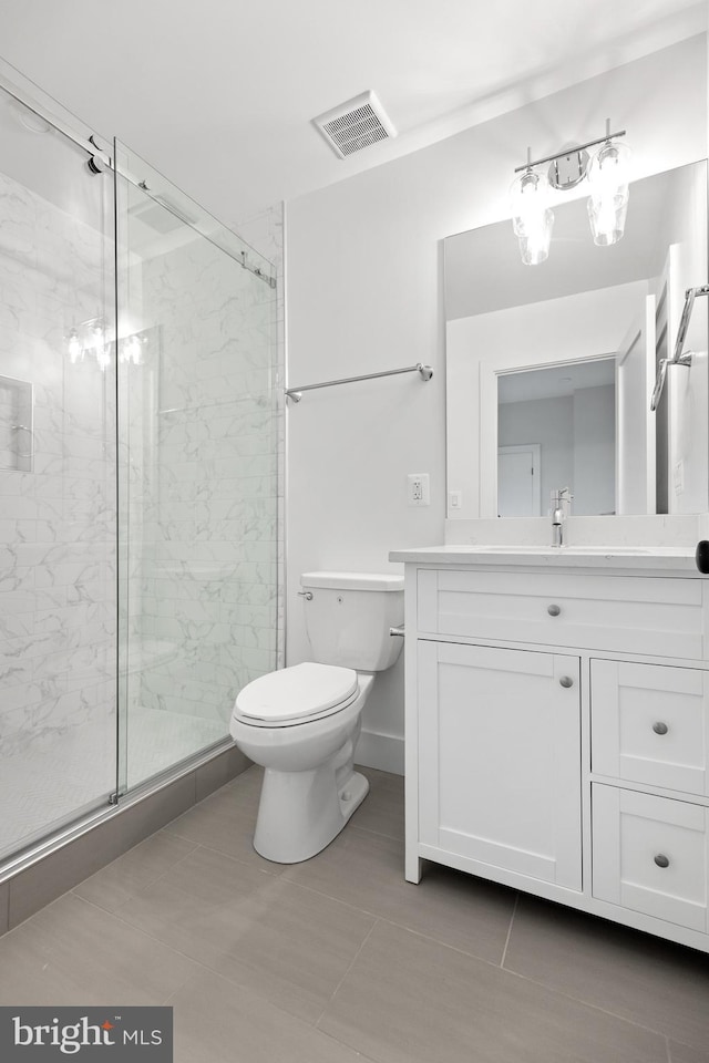 bathroom featuring an enclosed shower, vanity, tile patterned floors, and toilet