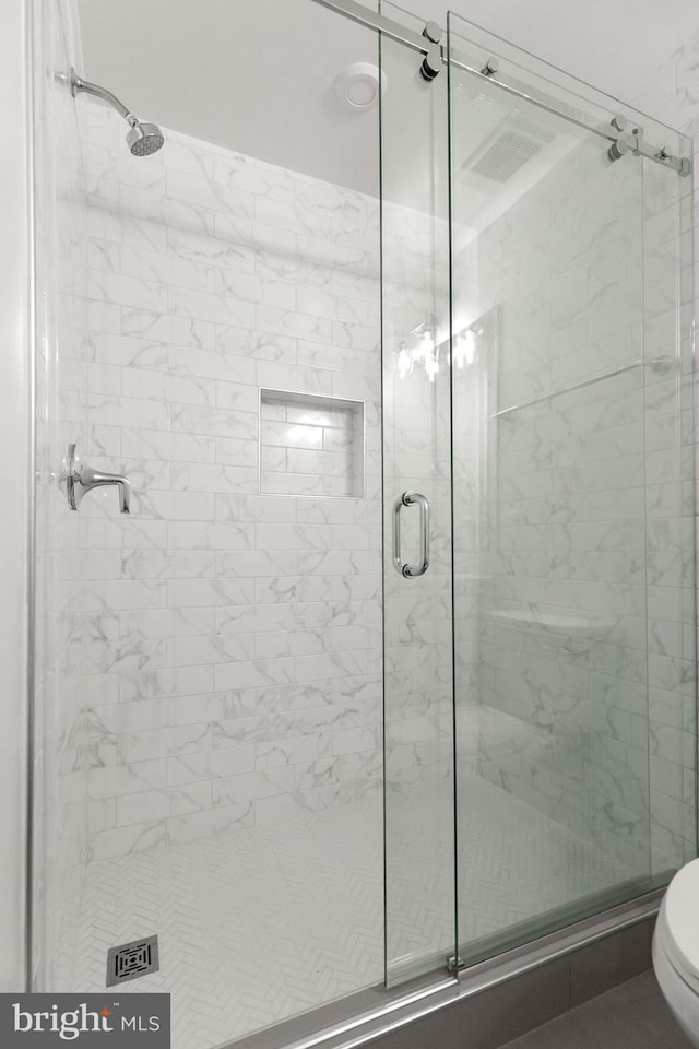 bathroom featuring toilet and an enclosed shower