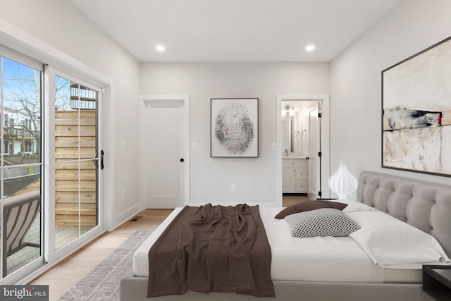 bedroom with ensuite bathroom, light hardwood / wood-style flooring, and access to outside