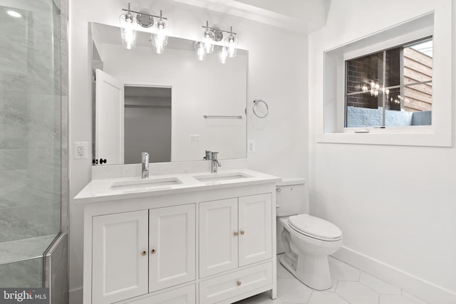 bathroom with toilet, vanity, and tile patterned floors