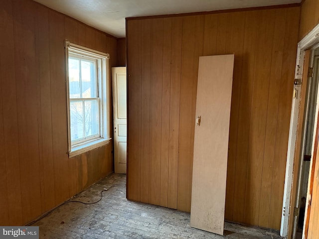 unfurnished bedroom with wooden walls