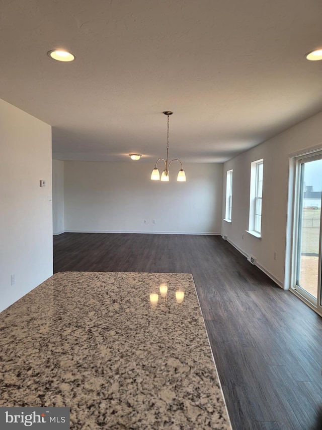 interior space featuring dark wood-type flooring and an inviting chandelier