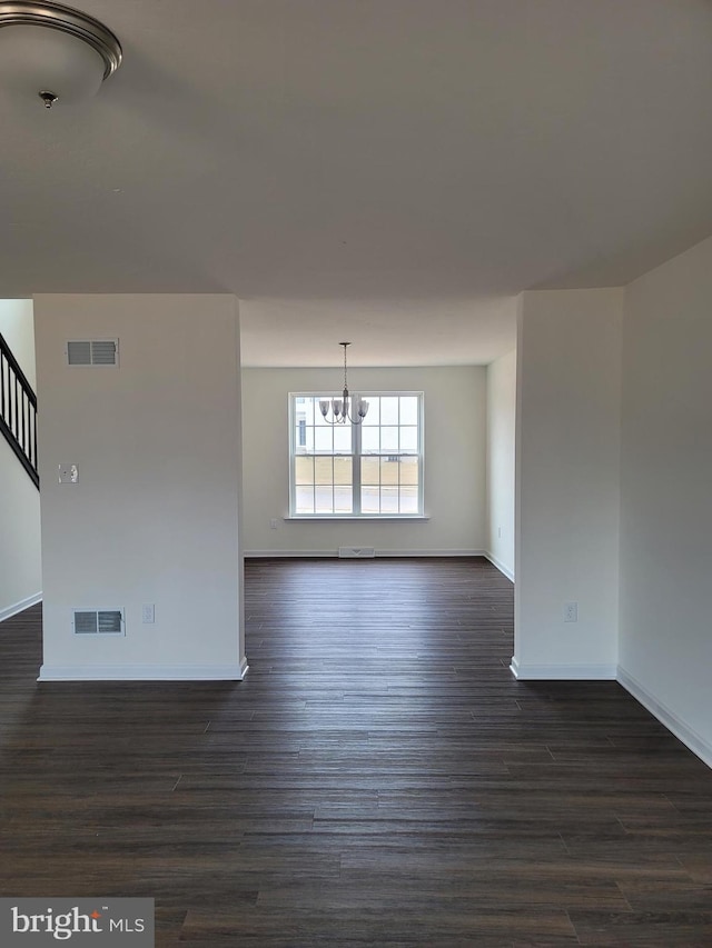 interior space featuring dark wood-type flooring and a chandelier