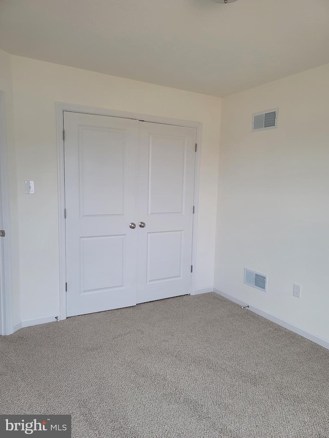 unfurnished bedroom with carpet flooring and a closet