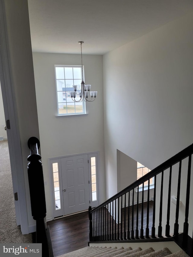 foyer entrance with dark hardwood / wood-style floors and a chandelier