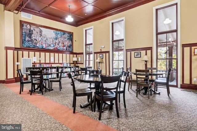 dining space featuring carpet flooring, a high ceiling, and wood ceiling