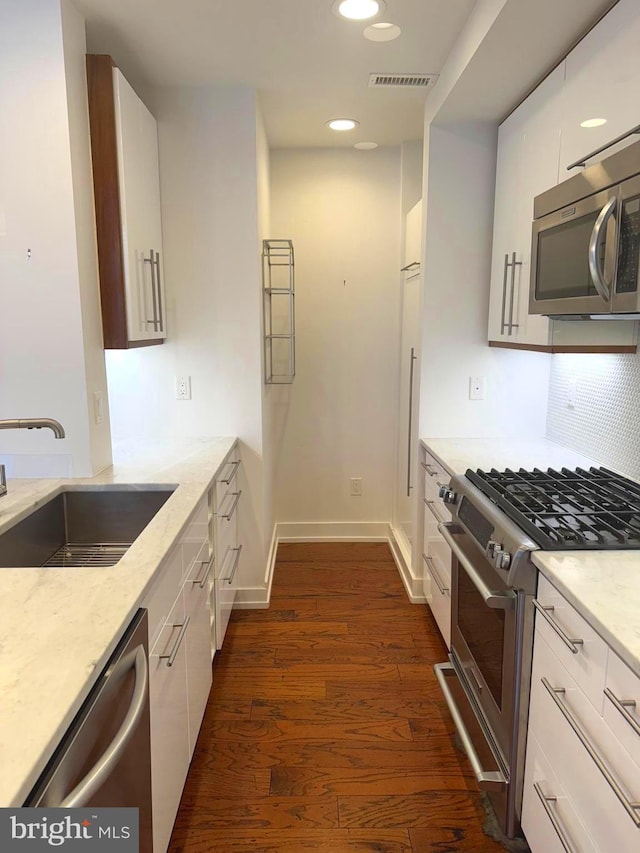 kitchen featuring appliances with stainless steel finishes, white cabinetry, and sink